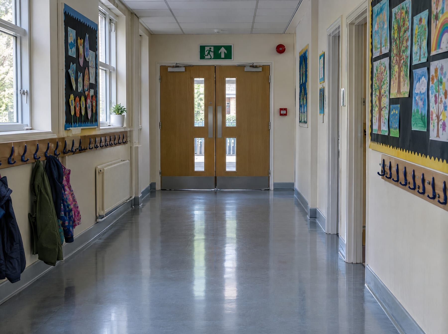 School corridor with fire doors, exit sign and alarm call point