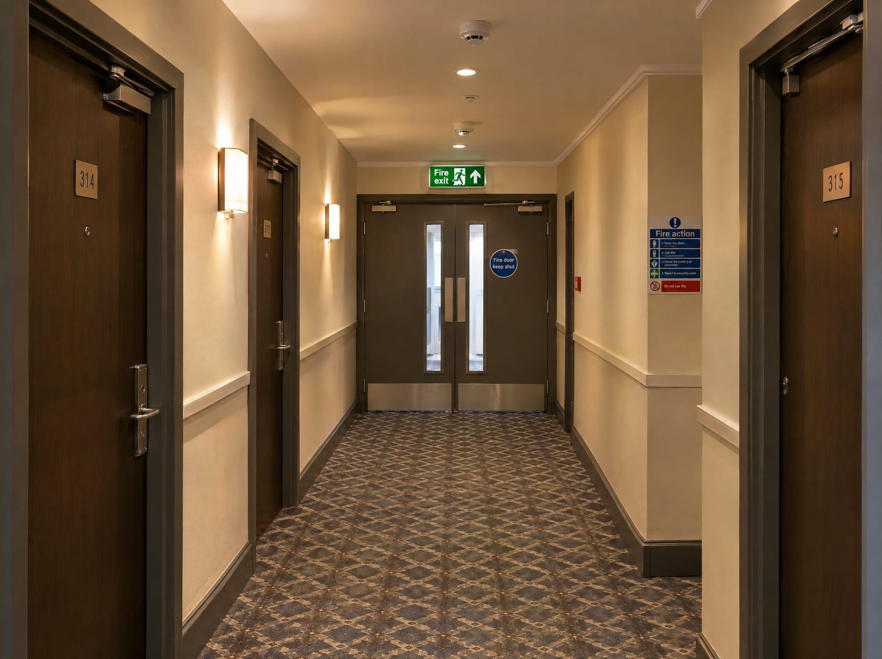 Hotel bedroom corridor with fire doors and fire exit sign