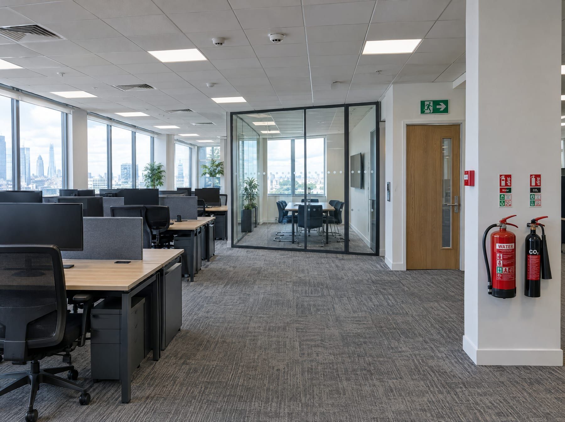 Open-plan office with fire exit sign, call point and extinguishers